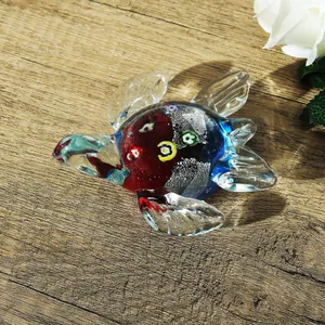 Figurine de tortue de mer en verre artisanal avec motifs colorés sur fond de bois