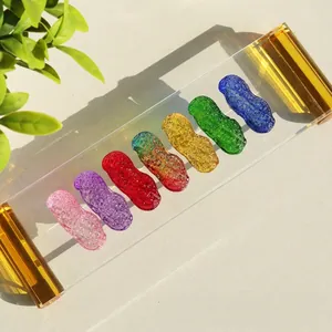 Bunte Kristall-Erdnuss-Glasornamente auf einem transparenten Display-Ständer