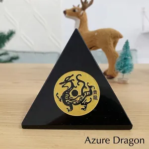 Close-up van zwart kristallen piramide-ornament met gouden Azure Dragon-motiefinleg