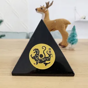 Detailopname van zwart piramide-ornament met gouden Witte Tijger-embleem