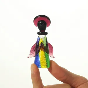Vista detallada de una figura de ángel de cristal colorida sostenida entre los dedos