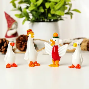 Gedetailleerd zicht op vier handgemaakte glazen eendfiguren op wit oppervlak.