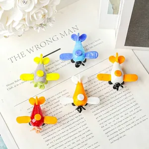 Set de cinco mini aviones de vidrio coloridos hechos a mano sobre fondo de revista decorativa