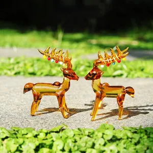 Detailed shot of amber glass reindeer figurines with colorful antler accents in a garden