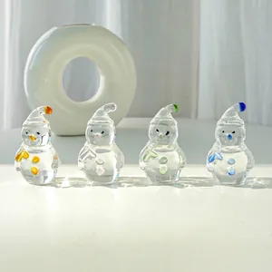 Detail view of four transparent crystal snowman figurines with colorful hats and buttons.