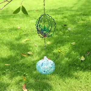 Outdoor butterfly wind spinner garden decoration with speckled blue glass ball hanging on a tree