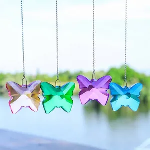 Gros plan de quatre attrape-soleil en cristal en forme de papillon coloré dehors