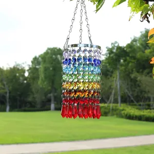 Detalle de un atrapasol de cristal arcoíris colgado en un exuberante entorno de jardín al aire libre
