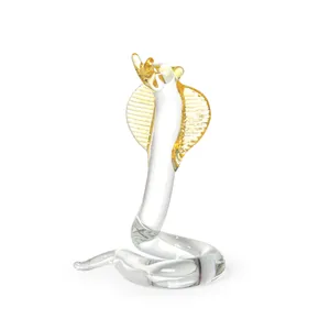 Handcrafted crystal cobra figurine with gold-tinted hood for luxury home decor.