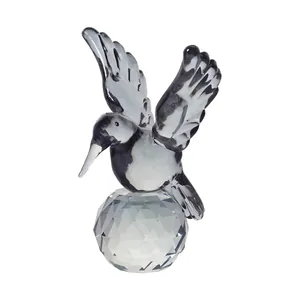 Detailweergave van een handgemaakt kristallen kolibri-beeldje op een gefacetteerde bolvoet
