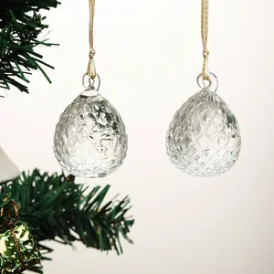 Primer plano de adornos navideños de cristal transparente colgados en un árbol