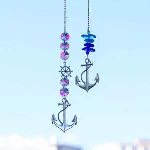 Detail von hängenden Anker und Steuerrad Sonnenfängern mit blau-pinken Kristallanhängern.