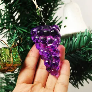 Primer plano de un adorno de uva de cristal púrpura brillante en un árbol de Navidad.