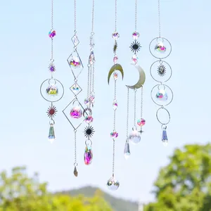 Detalle de seis atrapasoles de cristal con dijes de luna y estrella plateados al aire libre