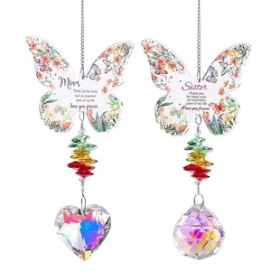 Vue détaillée d'attrape-soleil papillon fleuris avec prismes en cristal cœur pour la déco.