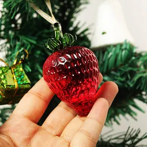 Vista macro detallada de un adorno de fresa de cristal rojo en un árbol de Navidad
