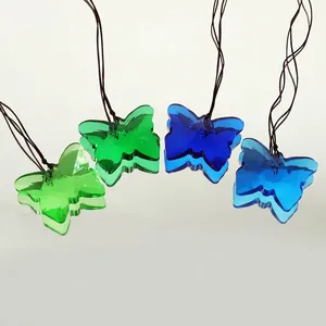 Detailed view of faceted crystal butterfly suncatcher pendants in vibrant green and blue.
