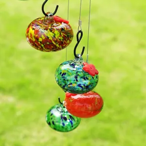 Détail de mangeoires pour oiseaux en verre soufflé en forme de pomme colorée