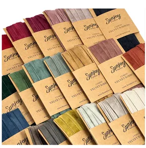 Macro view of various colorful velvet ribbons wrapped on kraft paper cards.