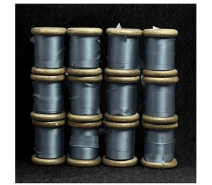 Close-up detail of 12 premium slate blue silk ribbons wound on vintage wooden spools