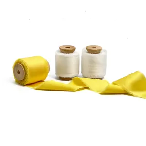 Handmade frayed edge silk ribbon on wooden spools for gift wrapping and floral decor