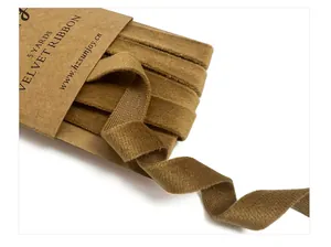 Detailed macro view of high-quality tan velvet ribbon with 5 yards cardboard packaging