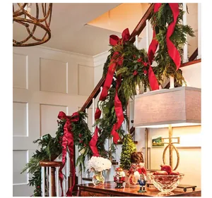 Detail of handmade red silk frayed edge ribbon decorating Christmas staircase garland
