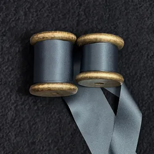 High-quality dark grey 100% silk cut-edge ribbon presented on vintage wooden spools