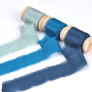 Frayed edge silk ribbon rolls with wooden spools for DIY wedding and gift wrapping.