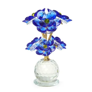 Elegante adorno de flores de cristal azul con tallos dorados para decoración del hogar.