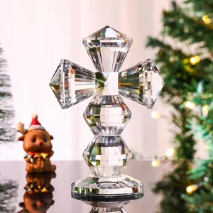 Detailed view of a faceted crystal cross ornament set against a festive Christmas background.