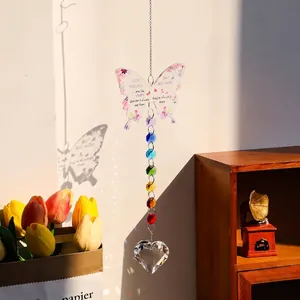 Détail d'un attrape-soleil papillon avec un prisme en cristal reflétant la lumière du jour