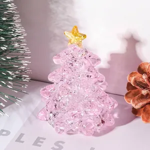 Dettaglio di un albero di Natale in cristallo rosa con una stella gialla in cima