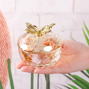 Close-up of a champagne glass jewelry box featuring an elegant golden butterfly lid