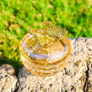 Detailed view of the golden filigree butterfly lid on a faceted glass jewelry box