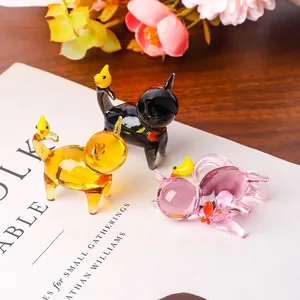 Detailed macro view of handcrafted glass cat figurines featuring small yellow birds