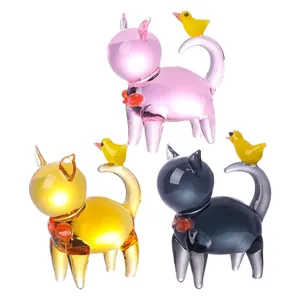 Detailed macro view of colorful handmade glass cat figurines with yellow birds on tails