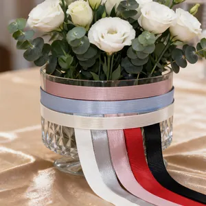 Assorted colorful grosgrain ribbons wrapped around a flower vase for DIY craft projects.