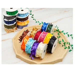 Detailed macro view of multiple colorful embossed leaf-shaped ribbons on white spools