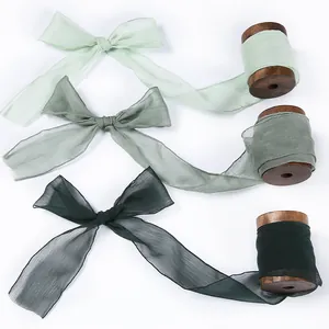 Elegant chiffon silk ribbons in three shades of green on vintage wooden spools for DIY crafts