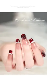 Vista dettagliata di elegante nail art rossa con delicate decorazioni in perle.