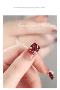 Primo piano di un fiocco rosso 3D per nail art con piccole perle bianche su un dito