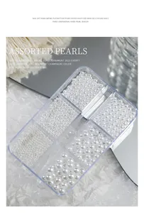Dettaglio di perle per nail art bianche lucide assortite in una scatola a 6 griglie