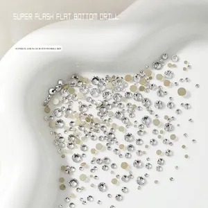 Assortiment platte fonkelende nail art steentjes en gouden studs op een wit hartplateau
