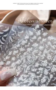 Detailed view of 3D embossed rose and ribbon nail stickers with pearl accents