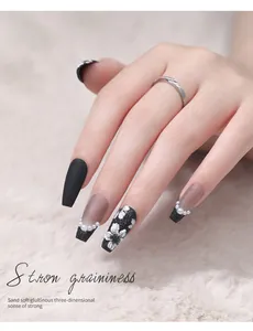 Gros plan sur un nail art 3D gaufré avec des motifs floraux baroques noirs et blancs