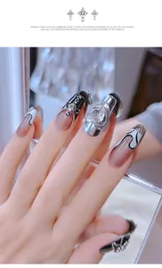 Gros plan de charmes d'ongles en métal punk rétro avec croix, crâne et strass en cœur