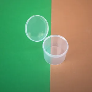 Close-up of open clear plastic round box with hinged lid showing hinge detail and transparency