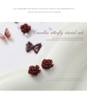Macro detail view of deep red resin camellia nail charms for elegant manicure decoration