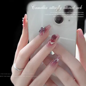 Elegant manicure set with 3D camellia and butterfly charms on pink gradient nails.